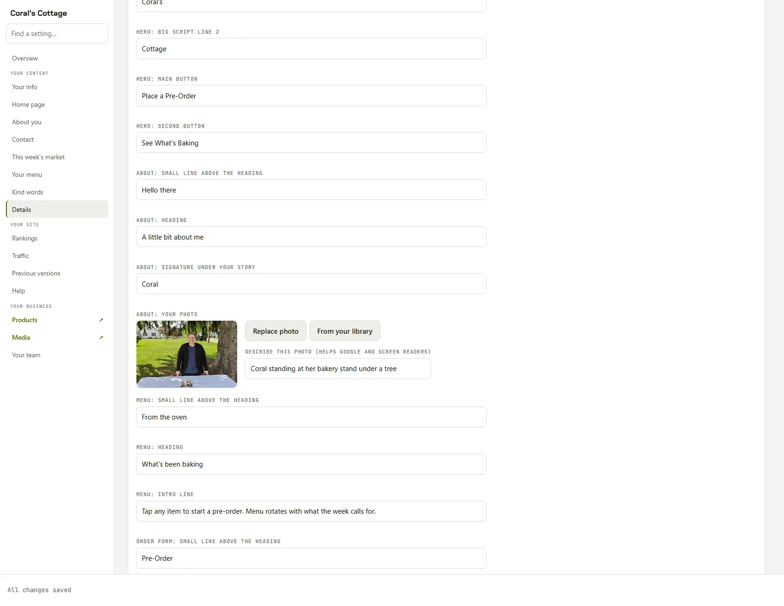 The Publisher editor for Coral's Cottage, a bakery site. A sidebar on the left lists the parts of the site. The main area shows plain text boxes labeled Hero: main button, About: heading, and Menu: intro line, plus a photo spot with Replace photo and From your library buttons.